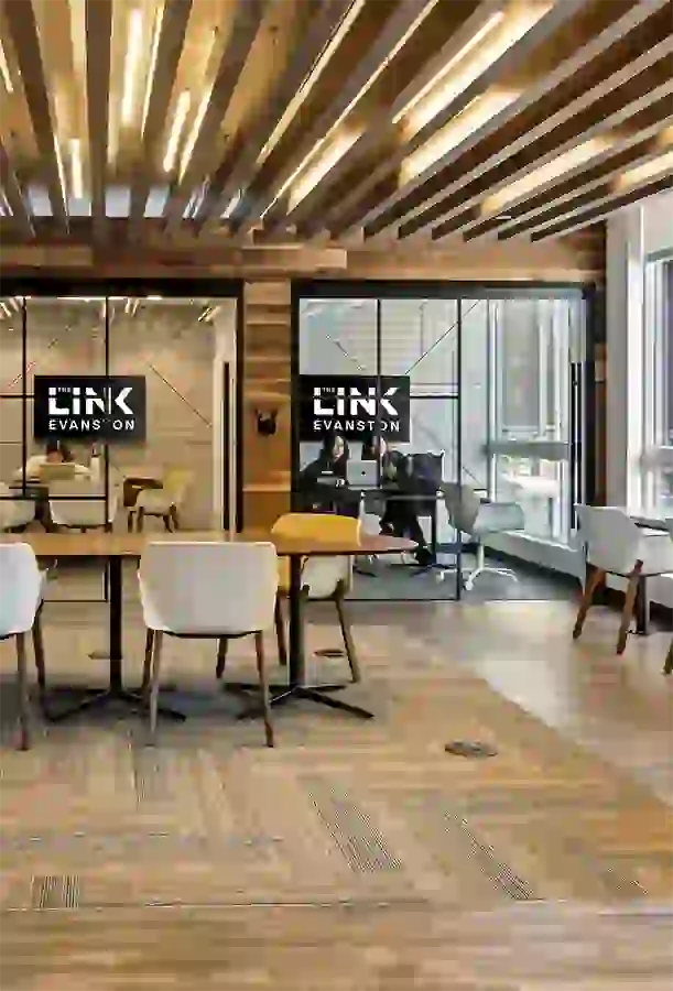 Collab desks with private meeting rooms in the background